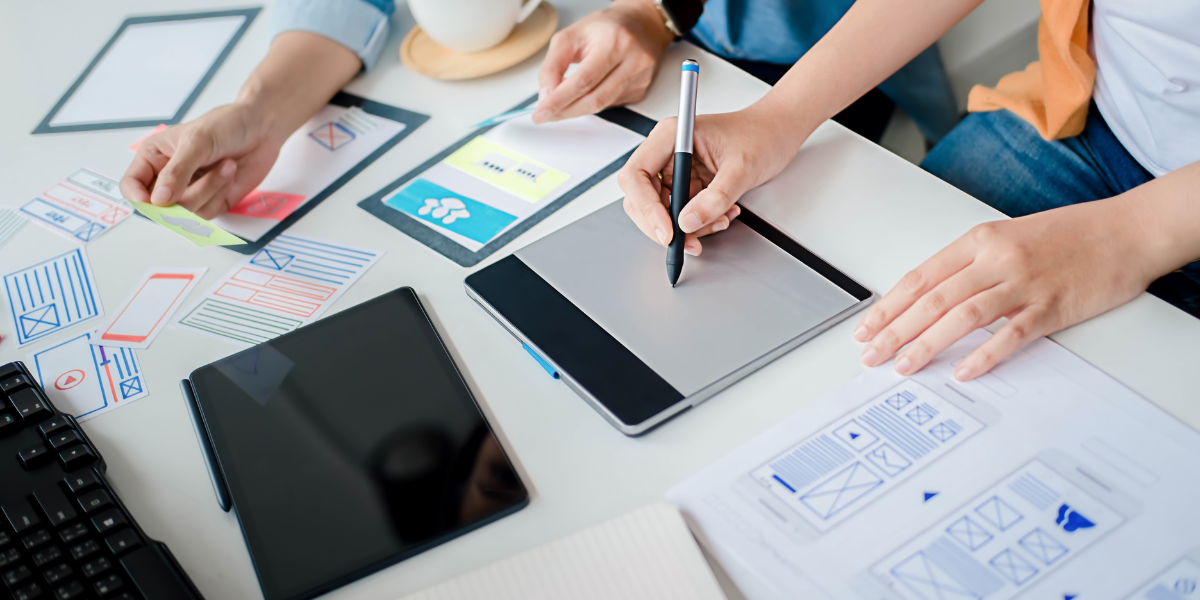 A diverse group collaborates on a laptop and documents, emphasizing teamwork in legal content creation for lead generation.