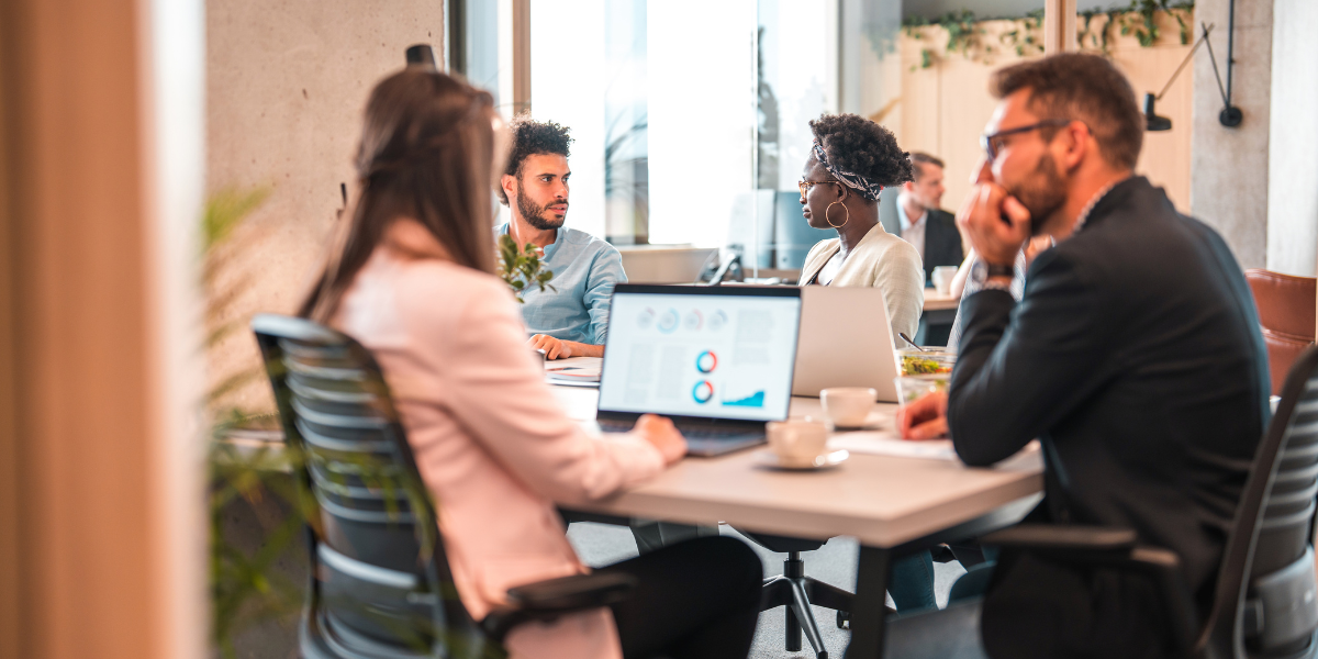 A group of professionals collaborating at a table, each using laptops to enhance their digital marketing strategies.