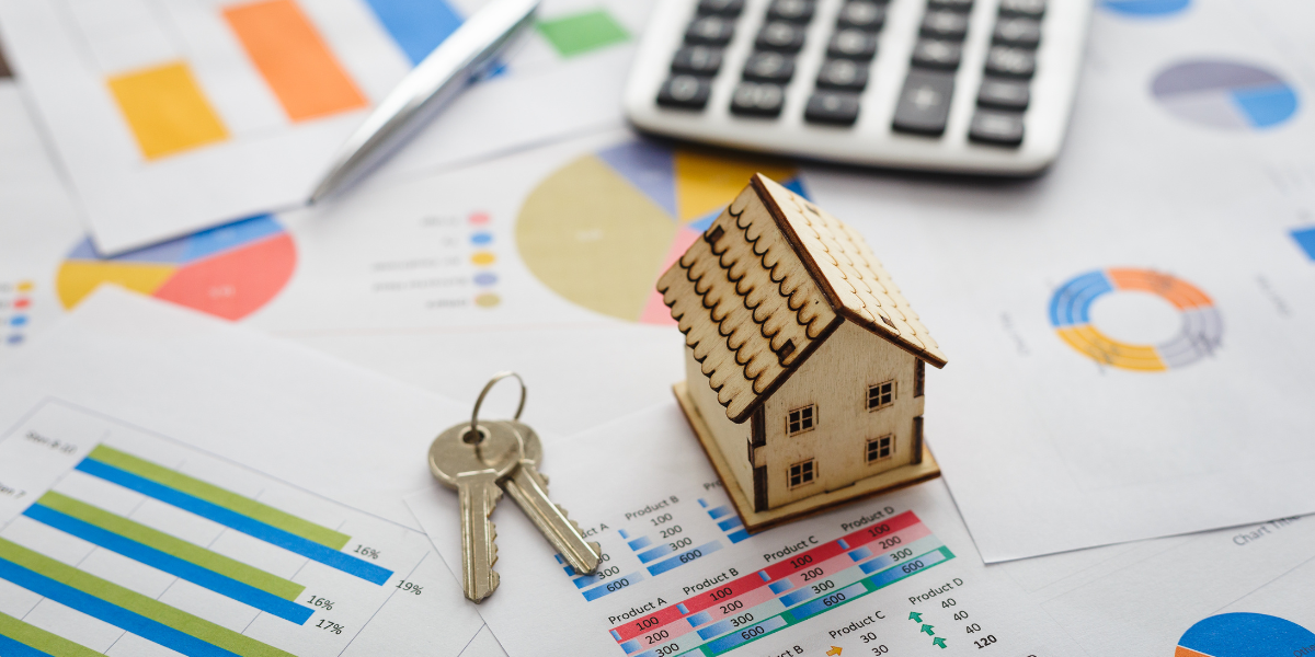 House model, calculator, key, and financial documents arranged on a desk, symbolizing real estate investment and planning.